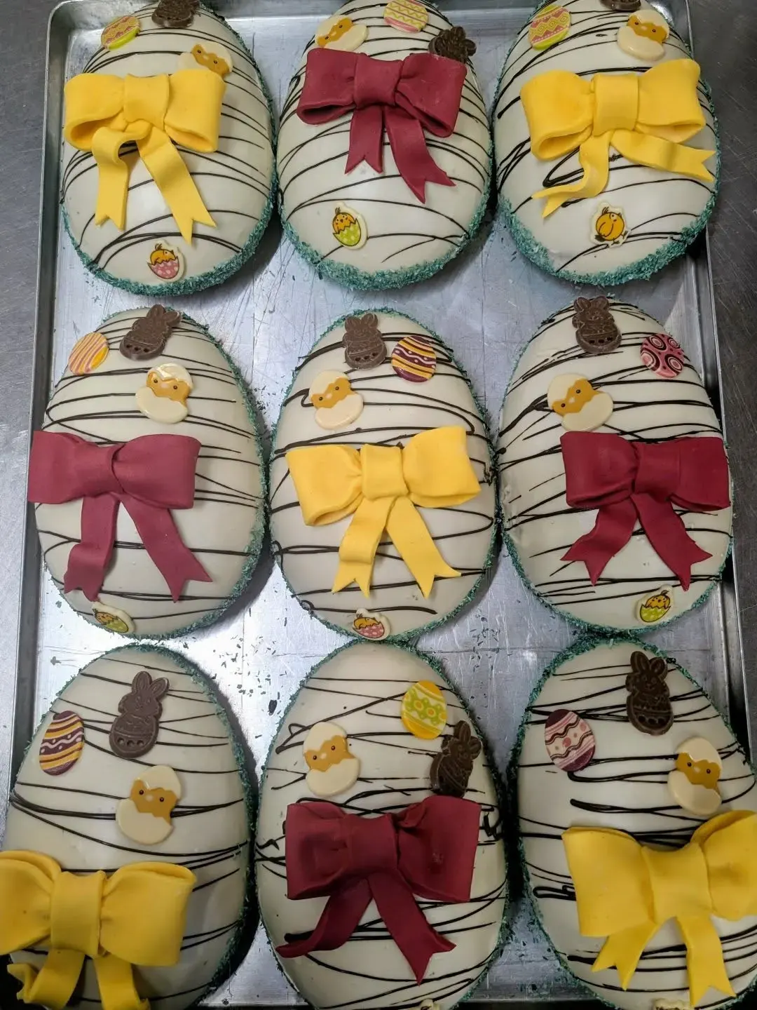 Osterbleche mit Schokoeiern, Schleifen und Marzipanküken